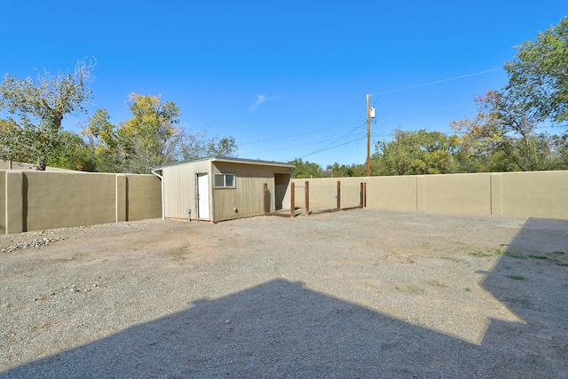 view of yard featuring an outbuilding, a shed, and fence