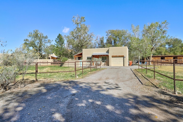 view of front of house with stucco siding, an outbuilding, driveway, an exterior structure, and a garage