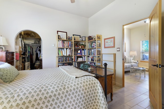 bedroom with a spacious closet, wood finished floors, and a closet