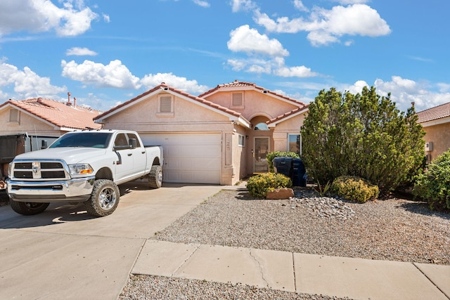 view of front of house with a tile roof, stucco siding, an attached garage, and concrete driveway