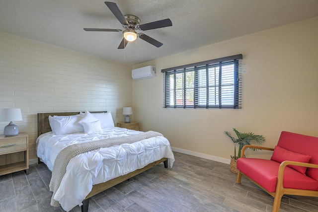 bedroom with baseboards, wood finished floors, a textured ceiling, a wall mounted AC, and a ceiling fan