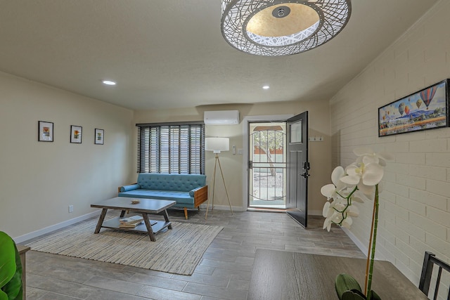 foyer entrance with a wall unit AC, wood finished floors, baseboards, brick wall, and recessed lighting