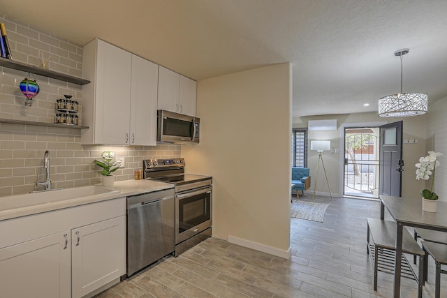 kitchen with open shelves, a sink, appliances with stainless steel finishes, white cabinetry, and backsplash