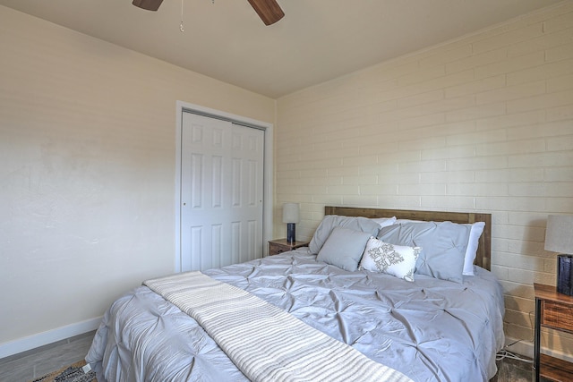 bedroom with a closet, a ceiling fan, baseboards, and wood finished floors