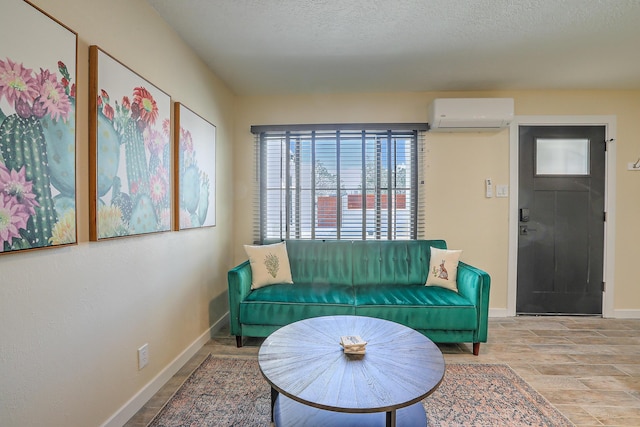 sitting room featuring a textured ceiling, an AC wall unit, and baseboards