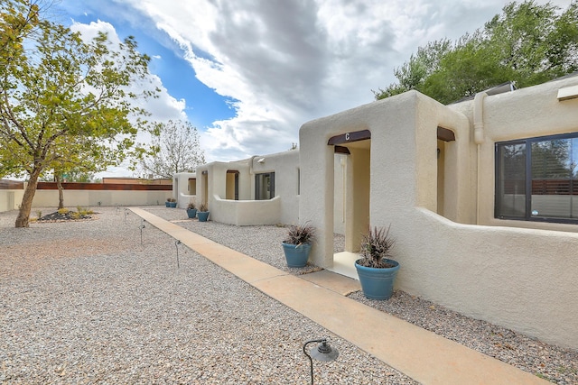 exterior space featuring stucco siding, a patio, and fence