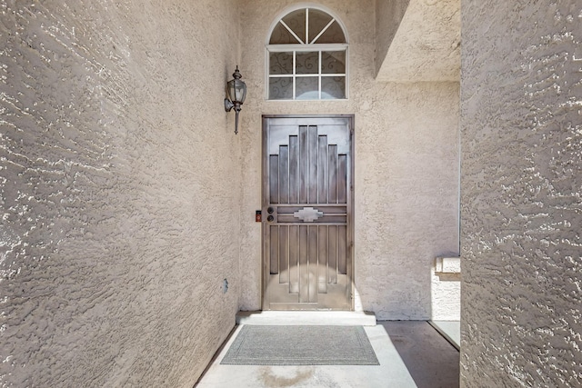 entrance to property featuring stucco siding