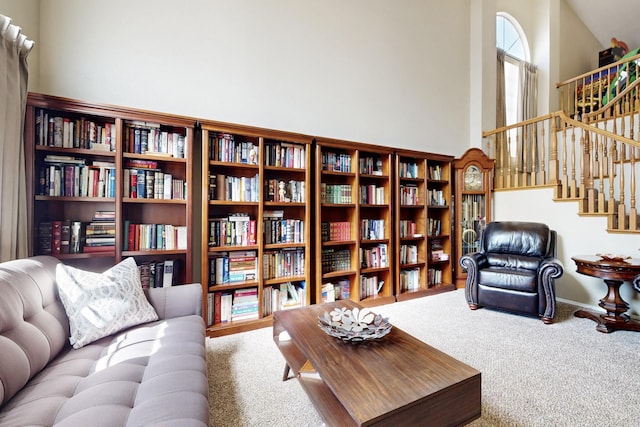 living room featuring stairs, a high ceiling, and carpet floors