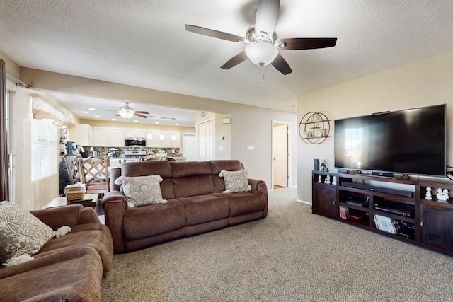 living room with carpet flooring, a textured ceiling, and a ceiling fan