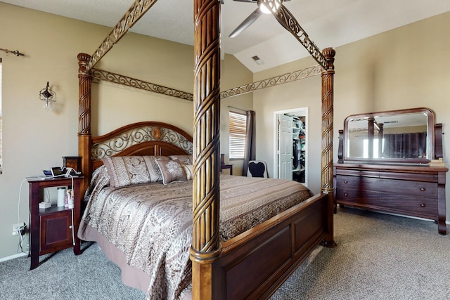 carpeted bedroom featuring a ceiling fan, visible vents, vaulted ceiling, a closet, and a walk in closet