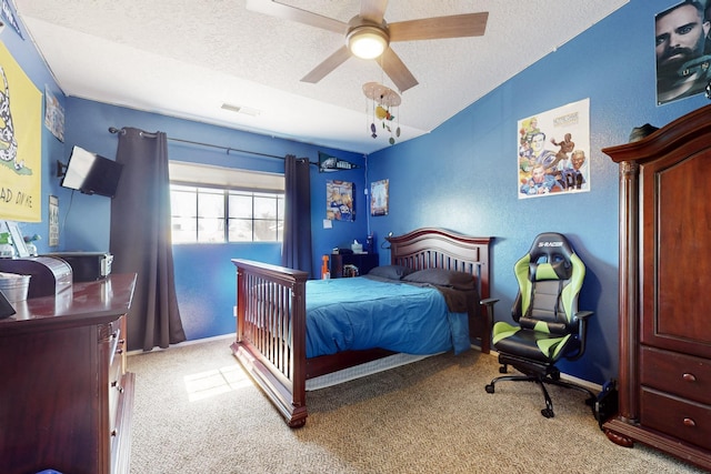 bedroom featuring visible vents, baseboards, light carpet, a textured ceiling, and a ceiling fan