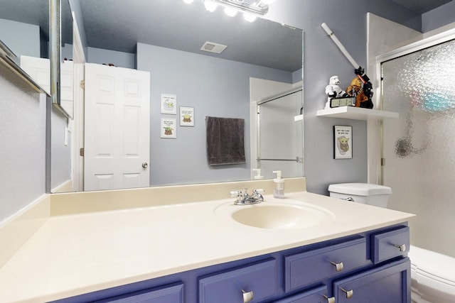 bathroom with visible vents, toilet, a stall shower, and vanity