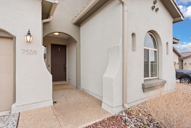 doorway to property featuring stucco siding