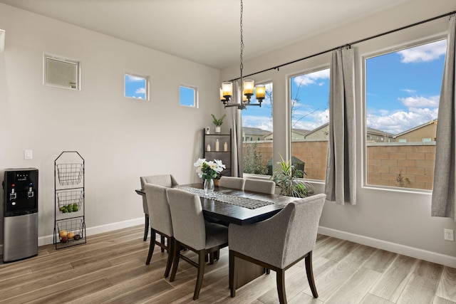 dining space featuring a notable chandelier, baseboards, and wood finished floors