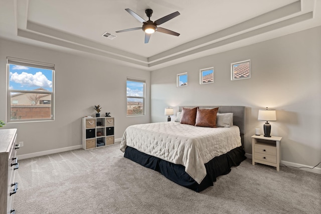 bedroom featuring carpet, a raised ceiling, visible vents, and baseboards