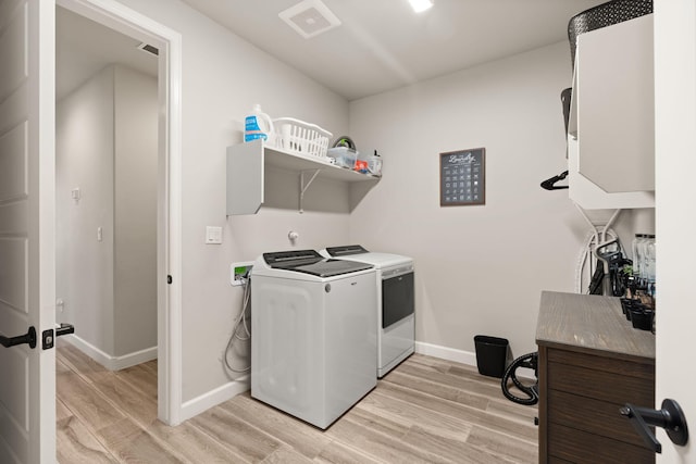 washroom with baseboards, light wood-style floors, laundry area, and independent washer and dryer
