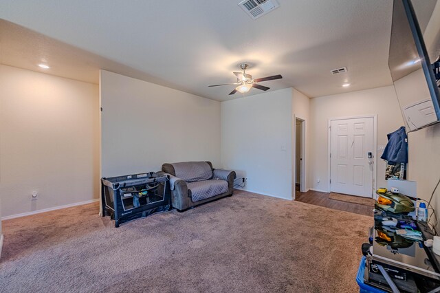 living area with a ceiling fan, carpet, and visible vents