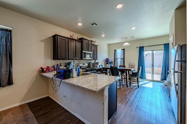 kitchen with visible vents, dark wood-type flooring, stainless steel appliances, baseboards, and dark brown cabinets