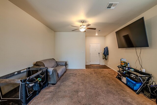 carpeted living area featuring visible vents and a ceiling fan