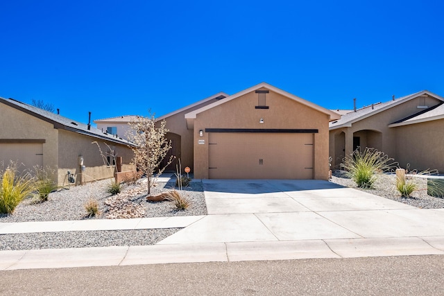 view of front facade with concrete driveway, an attached garage, and stucco siding