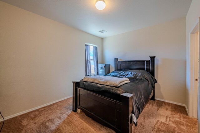 bedroom with visible vents, baseboards, and light colored carpet