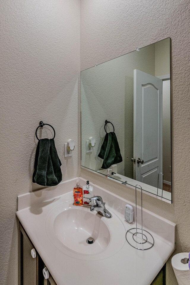 bathroom with vanity and a textured wall