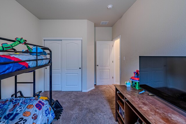 carpeted bedroom with visible vents, a closet, and baseboards