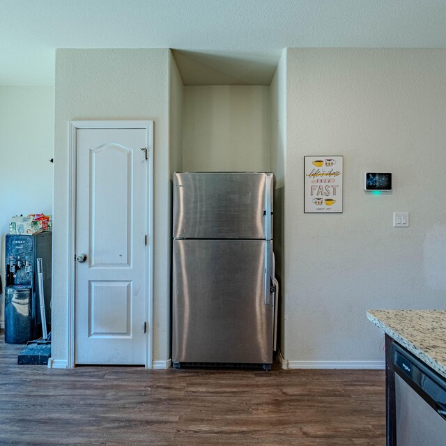 kitchen featuring dark wood finished floors, light stone countertops, baseboards, and stainless steel appliances