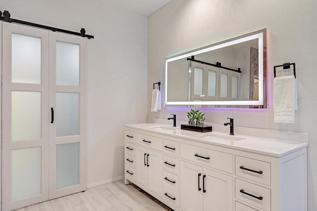 bathroom with a sink, baseboards, and double vanity