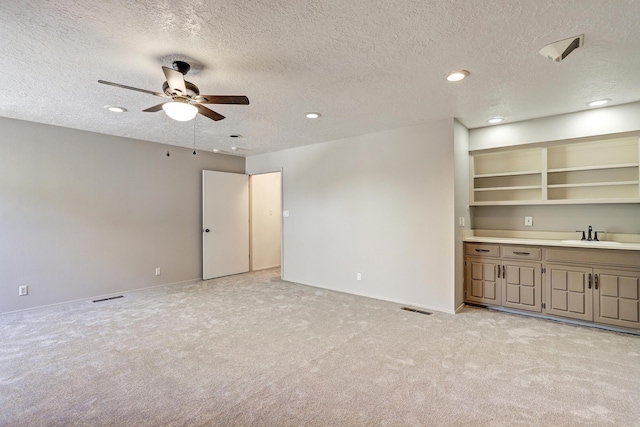 interior space featuring light carpet, visible vents, ceiling fan, and a sink