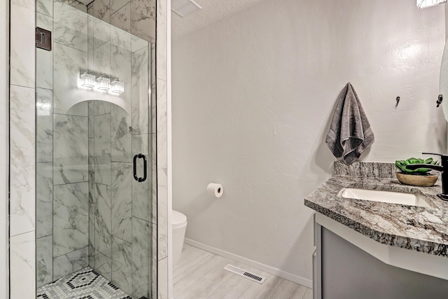 full bath with vanity, baseboards, visible vents, a stall shower, and toilet