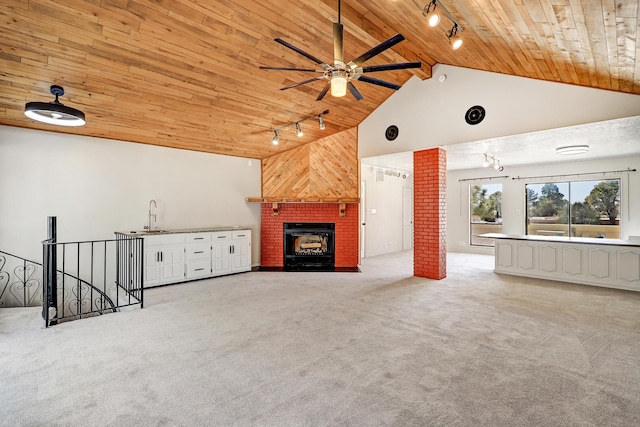 unfurnished living room featuring carpet, wood ceiling, a fireplace, and rail lighting