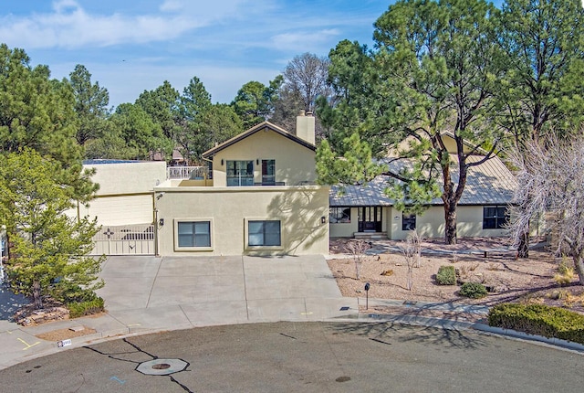 view of front of property with stucco siding, a balcony, and a chimney