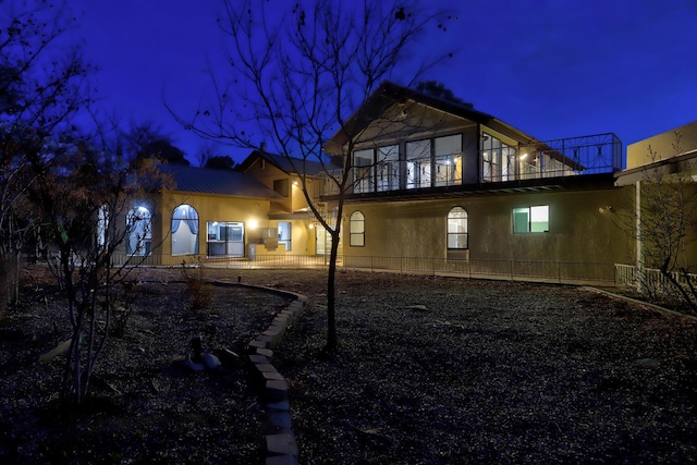 back of house at night featuring metal roof