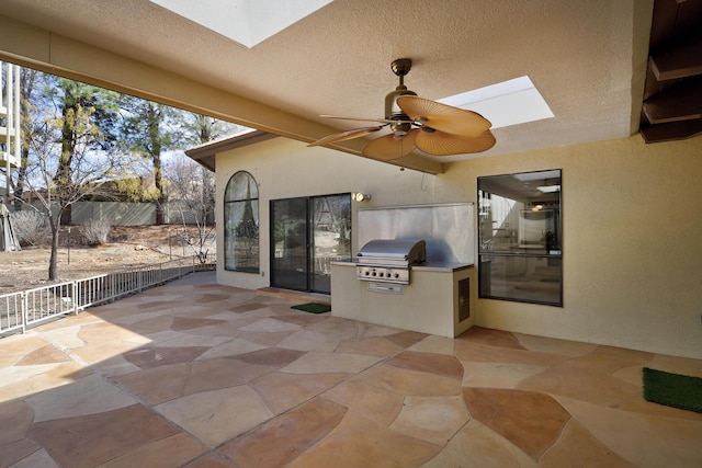 view of patio featuring a grill, exterior kitchen, and a ceiling fan