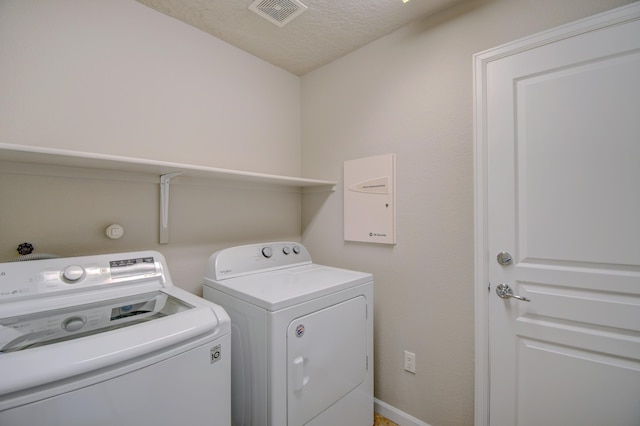 laundry area featuring visible vents, a textured ceiling, laundry area, and separate washer and dryer