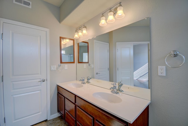 bathroom with double vanity, visible vents, and a sink