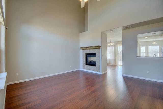 unfurnished living room featuring visible vents, a fireplace, dark wood-type flooring, and baseboards