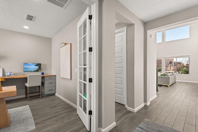 office area featuring visible vents, baseboards, and wood finished floors