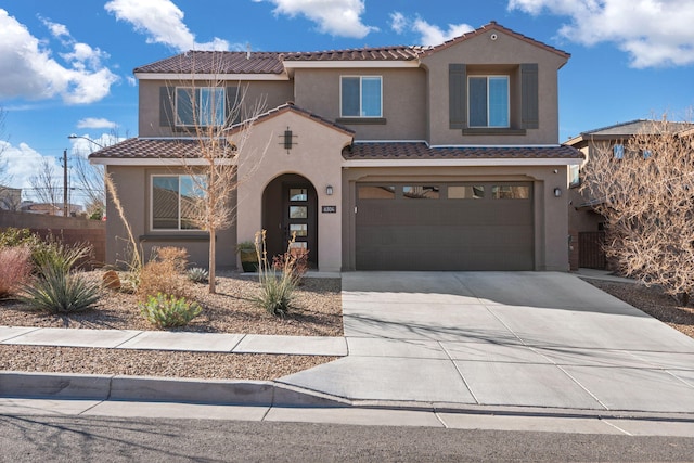 mediterranean / spanish-style house with fence, an attached garage, stucco siding, concrete driveway, and a tiled roof