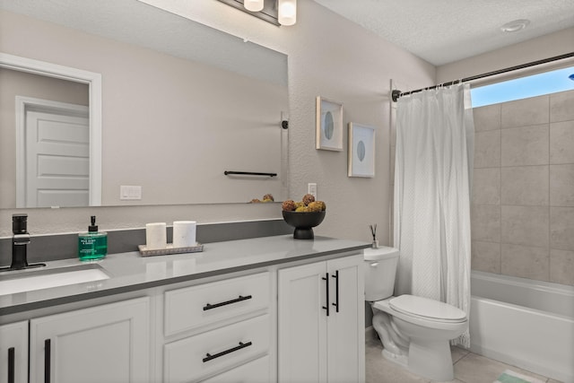 bathroom featuring tile patterned floors, toilet, vanity, and a textured ceiling