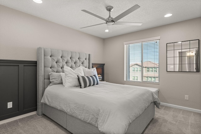 bedroom featuring baseboards, recessed lighting, ceiling fan, a textured ceiling, and light colored carpet