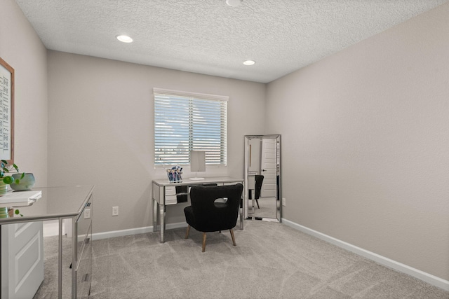 office space featuring a textured ceiling, recessed lighting, baseboards, and light carpet