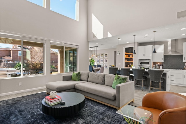 living area with recessed lighting, light wood-type flooring, and baseboards