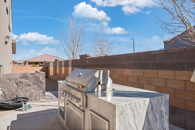 view of patio featuring grilling area, exterior kitchen, and a fenced backyard