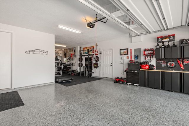 garage with electric panel, a workshop area, and a garage door opener