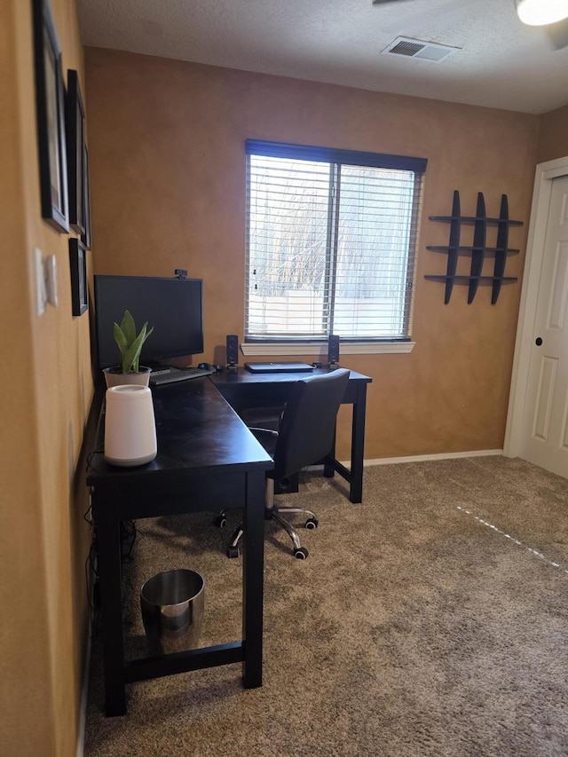 office featuring visible vents, baseboards, carpet, and a textured ceiling