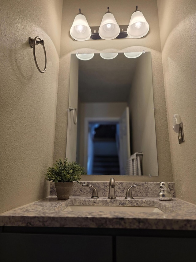 bathroom featuring vanity and a textured wall