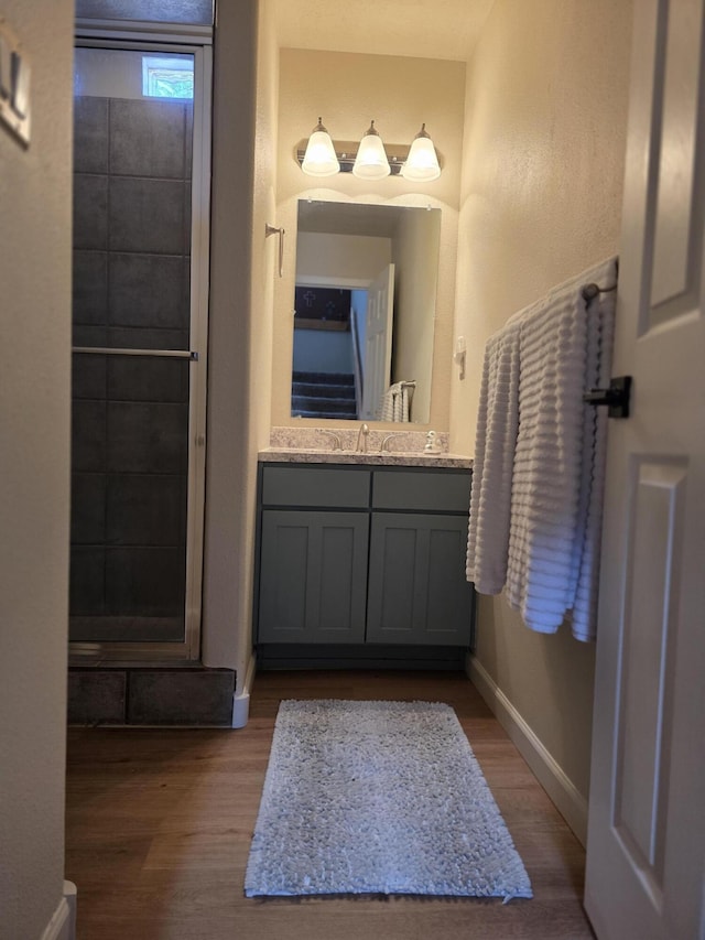 bathroom featuring vanity, wood finished floors, and baseboards