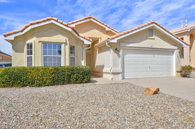 view of front of property with concrete driveway, a tiled roof, a garage, and stucco siding